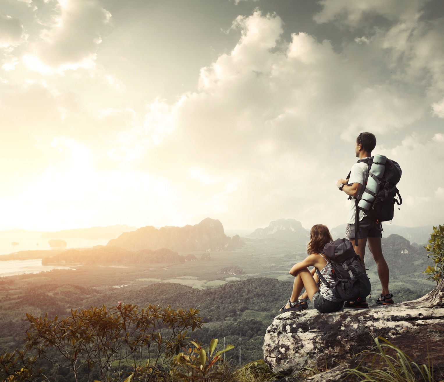Hikers Hikers with backpacks enjoying valley view from top of a mountain